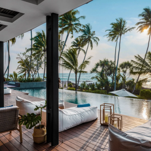 Luxuri&ouml;ses Boutique-Hotel mit Infinity-Pool und Liegen auf Holzdeck, Palmen und Meerblick in Sri Lanka